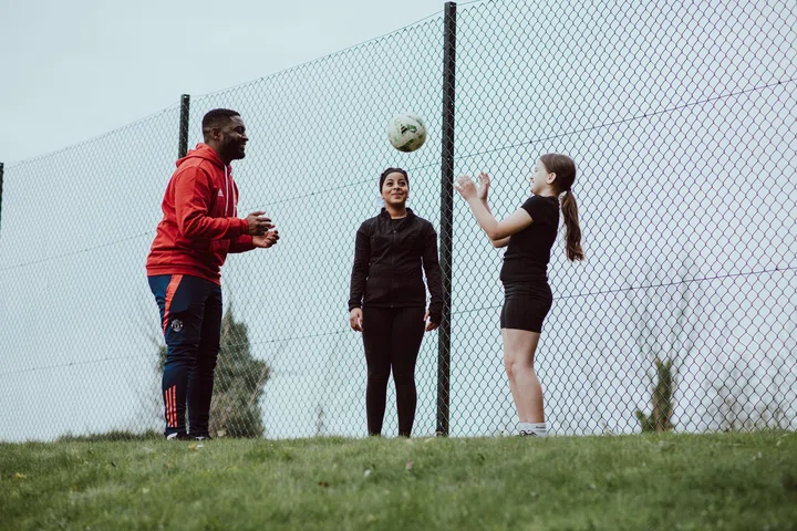 Foundation - generic image of coach and female participants playing football at The Cliff