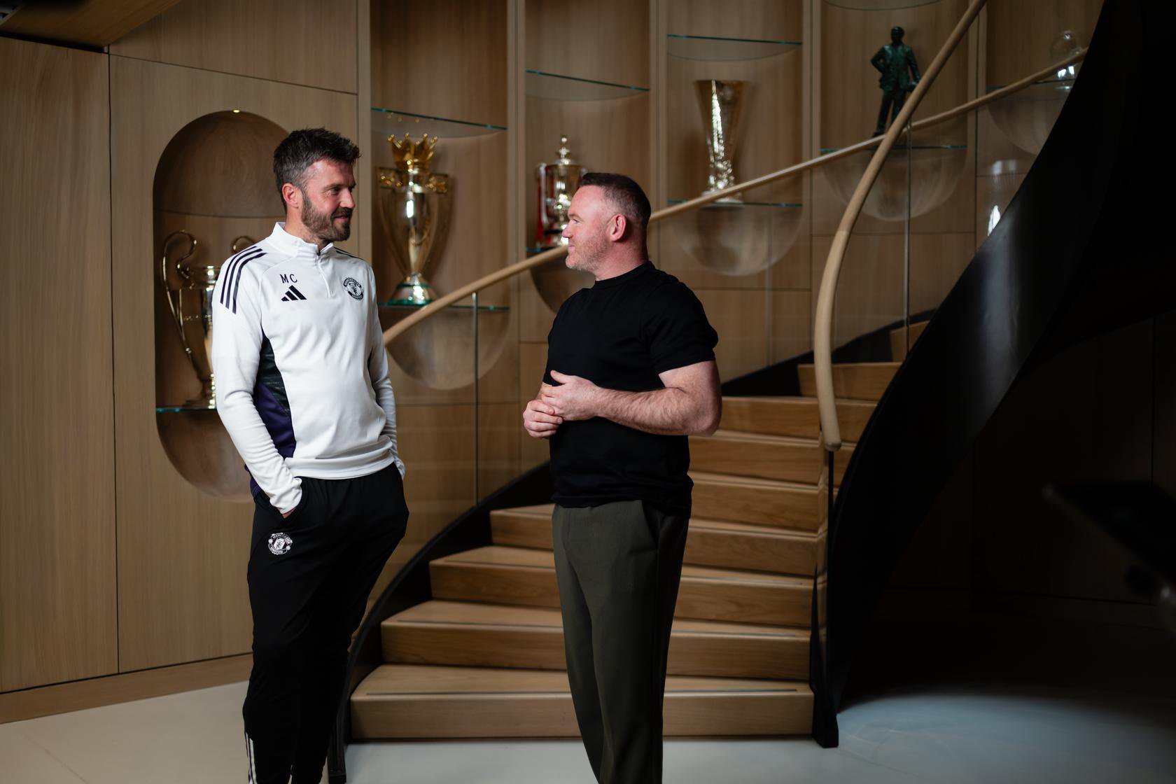 Michael Carrick and Wayne Rooney in front of trophies