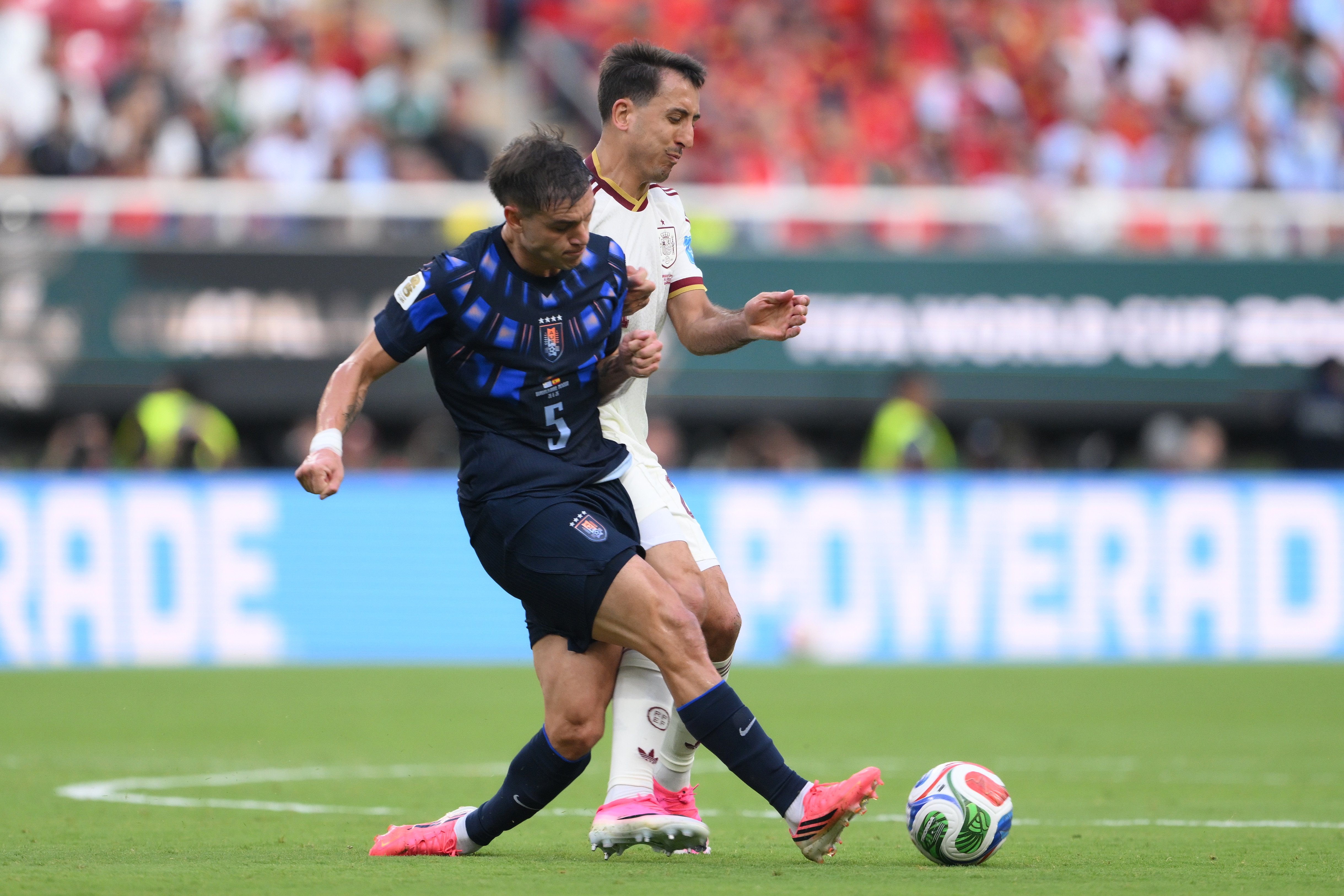 Manuel Ugarte competing for possession with Spain's Mikel Oyarzabal at the World Cup