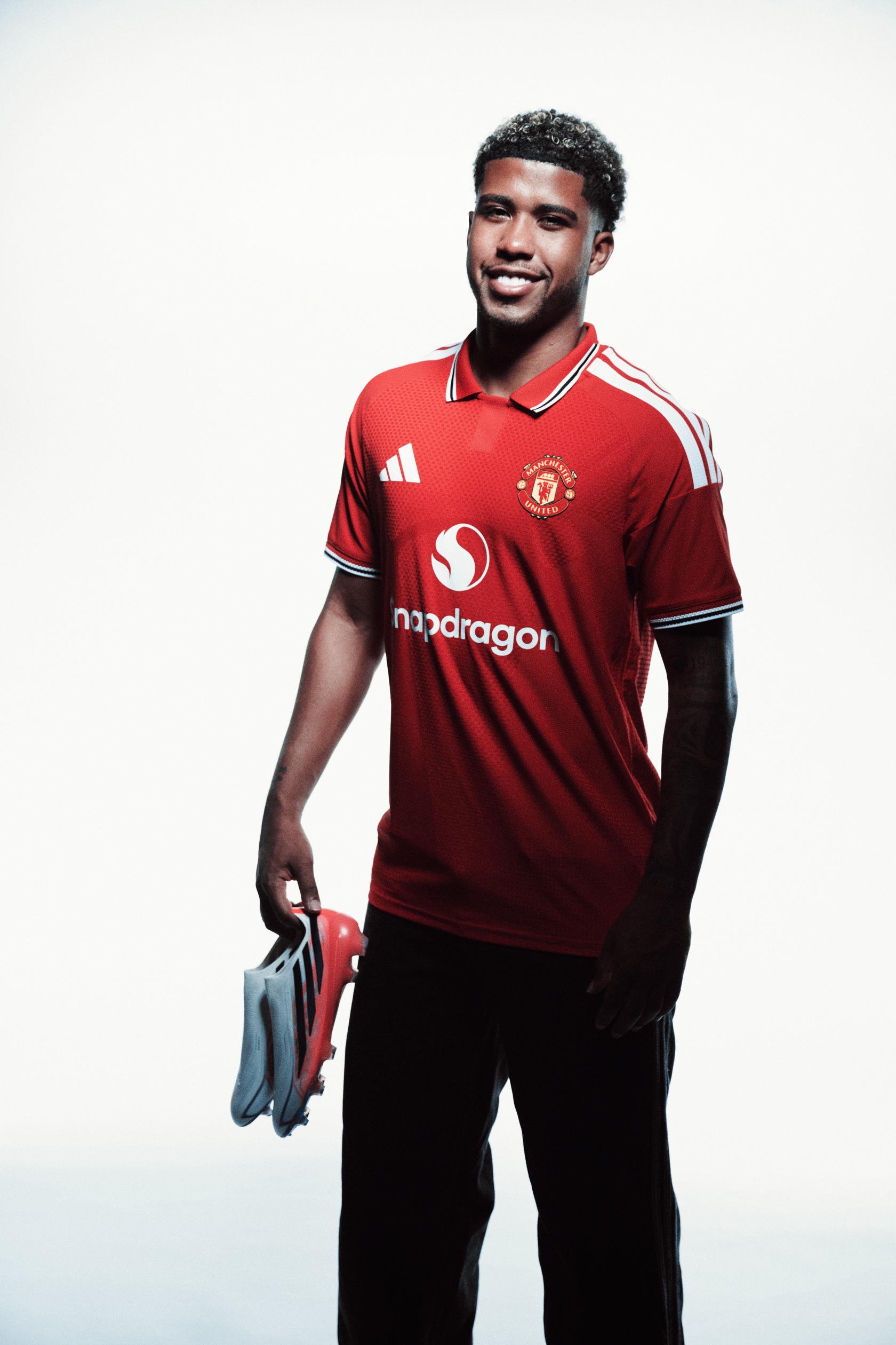Andrey Santos smiling and holding boots