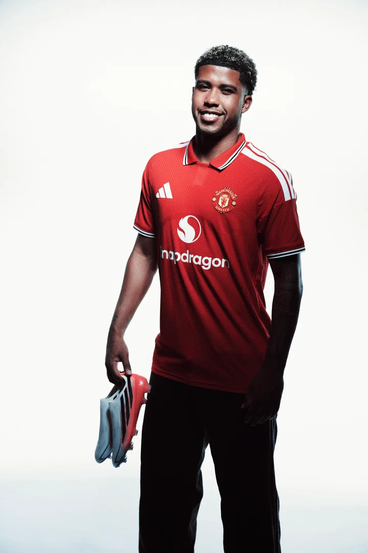 Andrey Santos smiling and holding boots