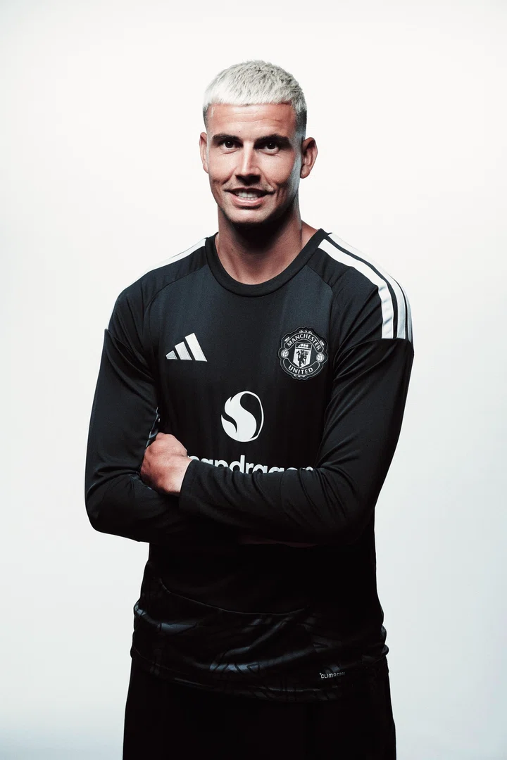 Karl Darlow smiling with arms folded in black goalkeeper kit