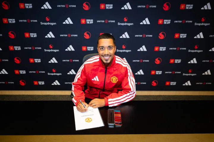 Youri Tielemans facing forward and smiling as he signs Manchester United contract