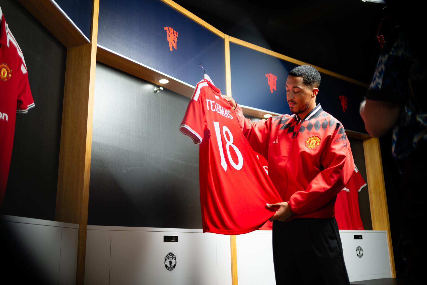 Youri Tielemans looks down at the back of his new Manchester United shirt