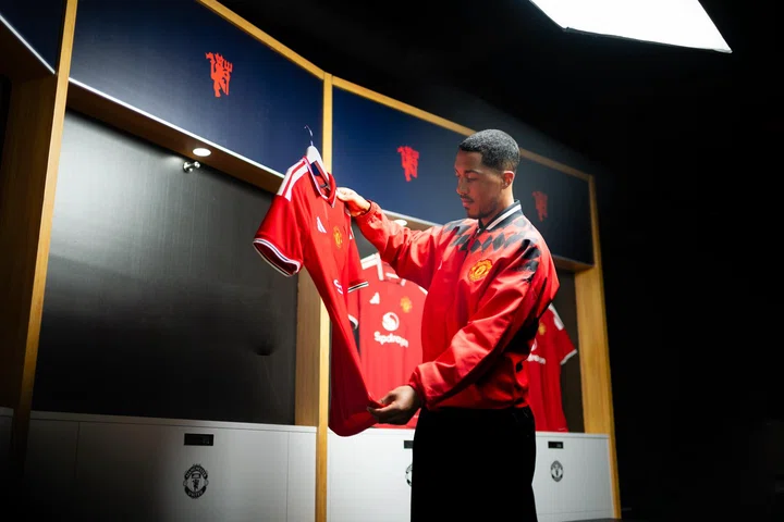 Youri Tielemans holding new United shirt on a hanger