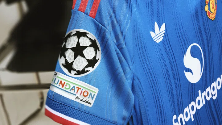 Champions League badges on 26/27 away kit