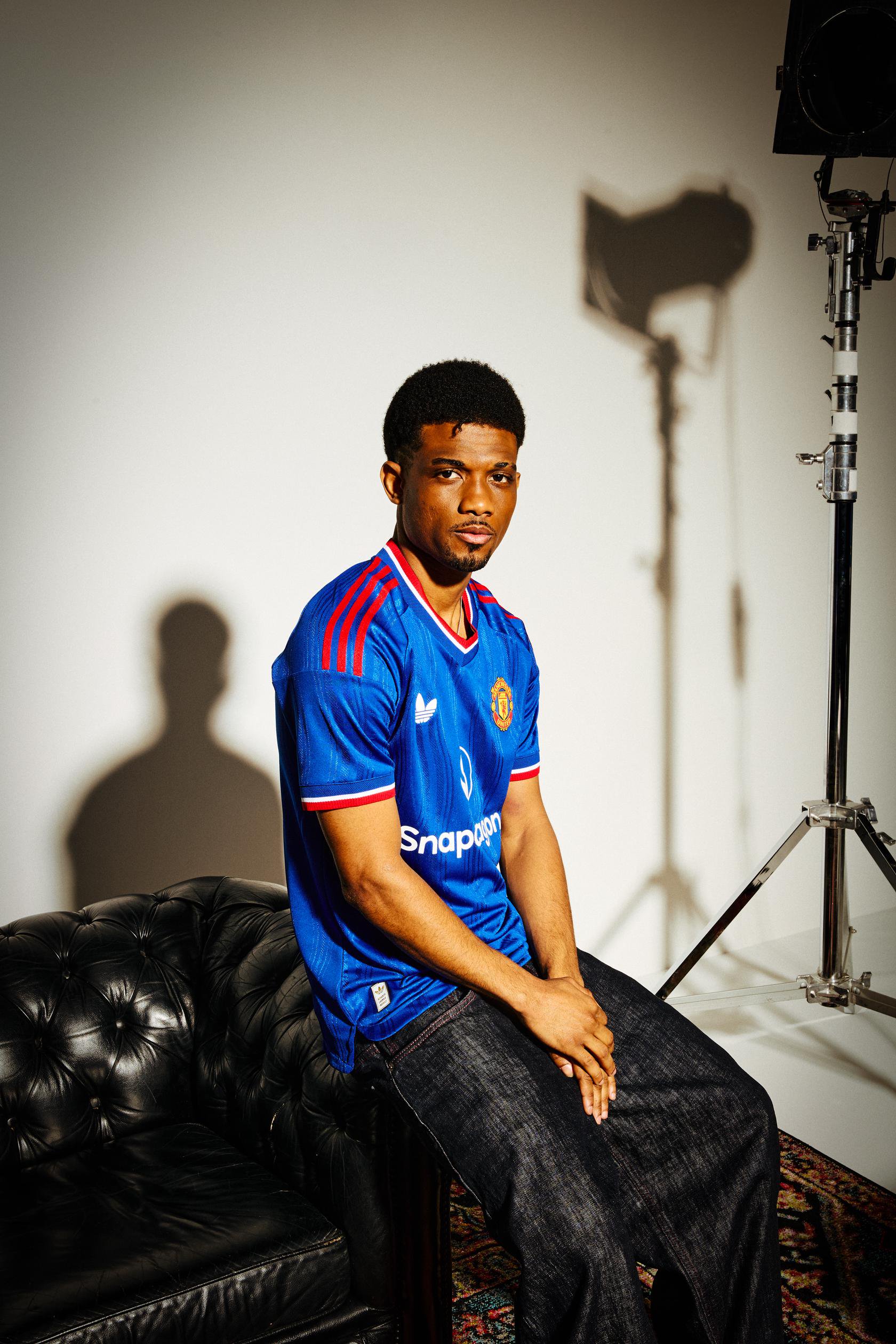 Amad sitting down in blue top