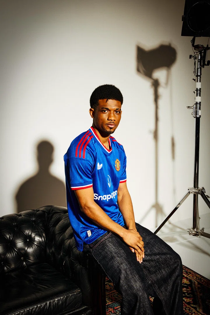 Amad sitting down in blue top