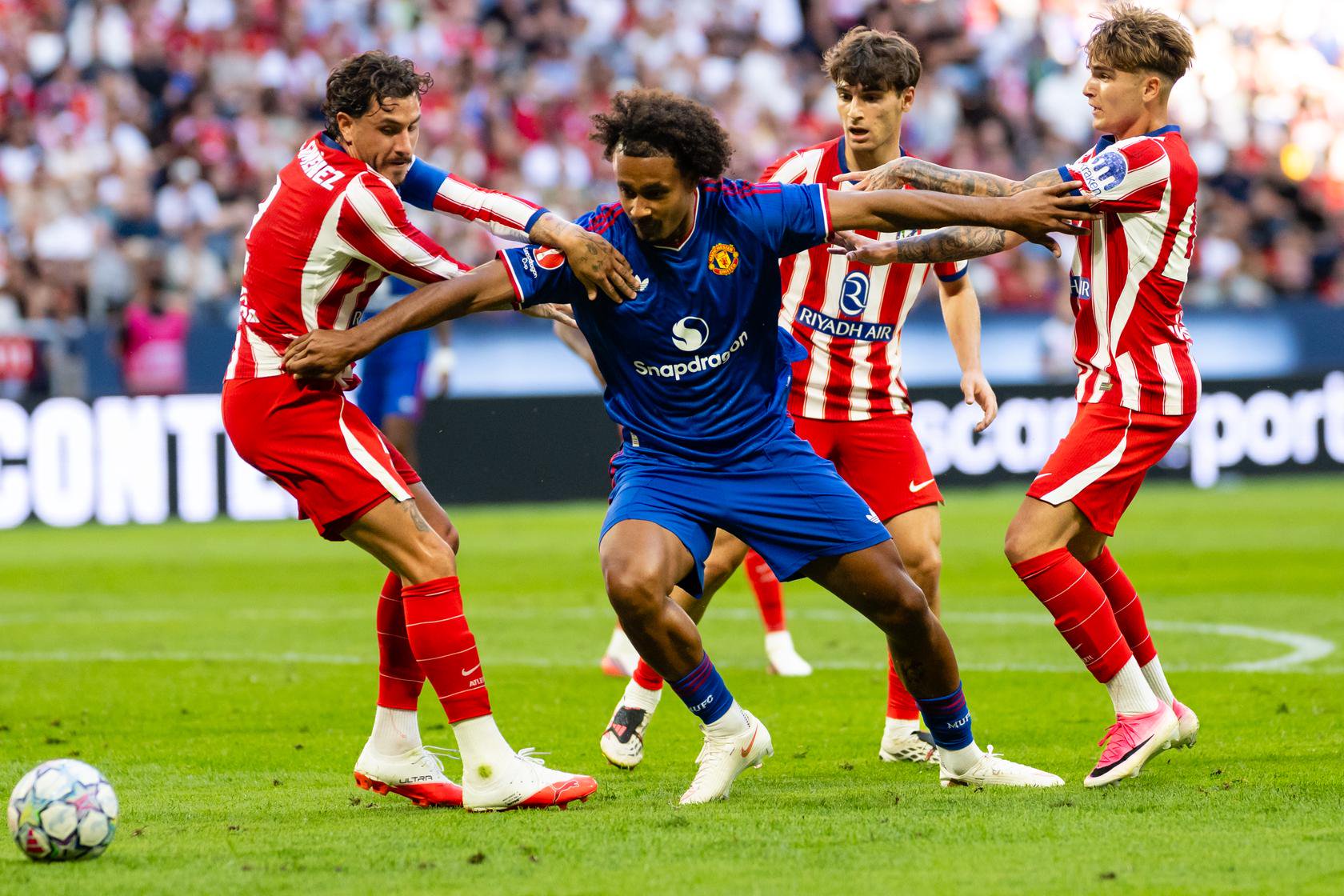 Joshua Zirkzee holds off Atletico de Madrid players