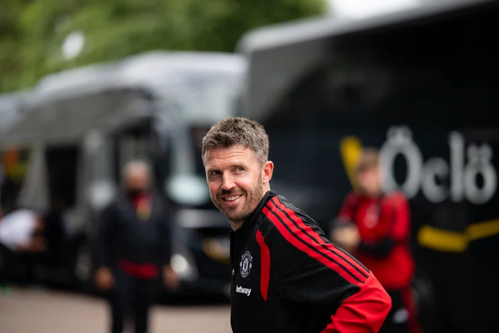 Michael Carrick in front of the coach smiling