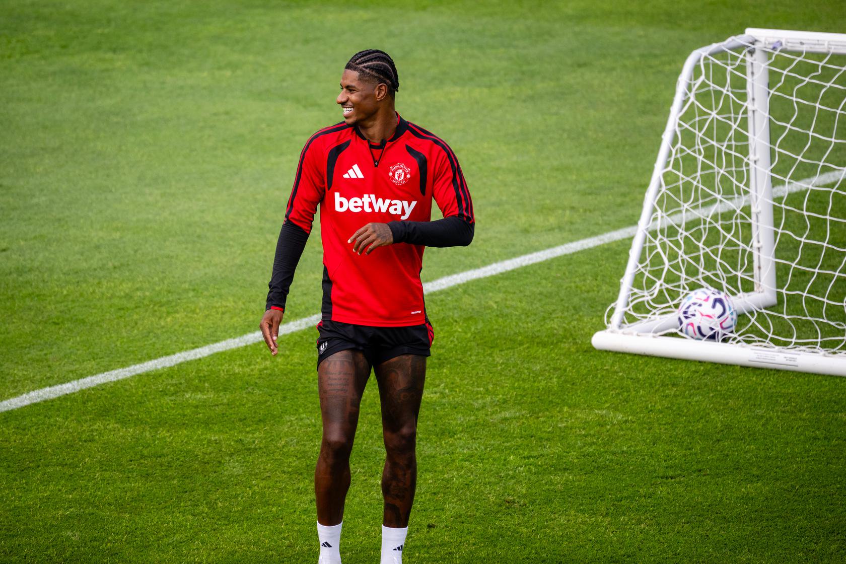 Marcus Rashford smiles at training 12 August
