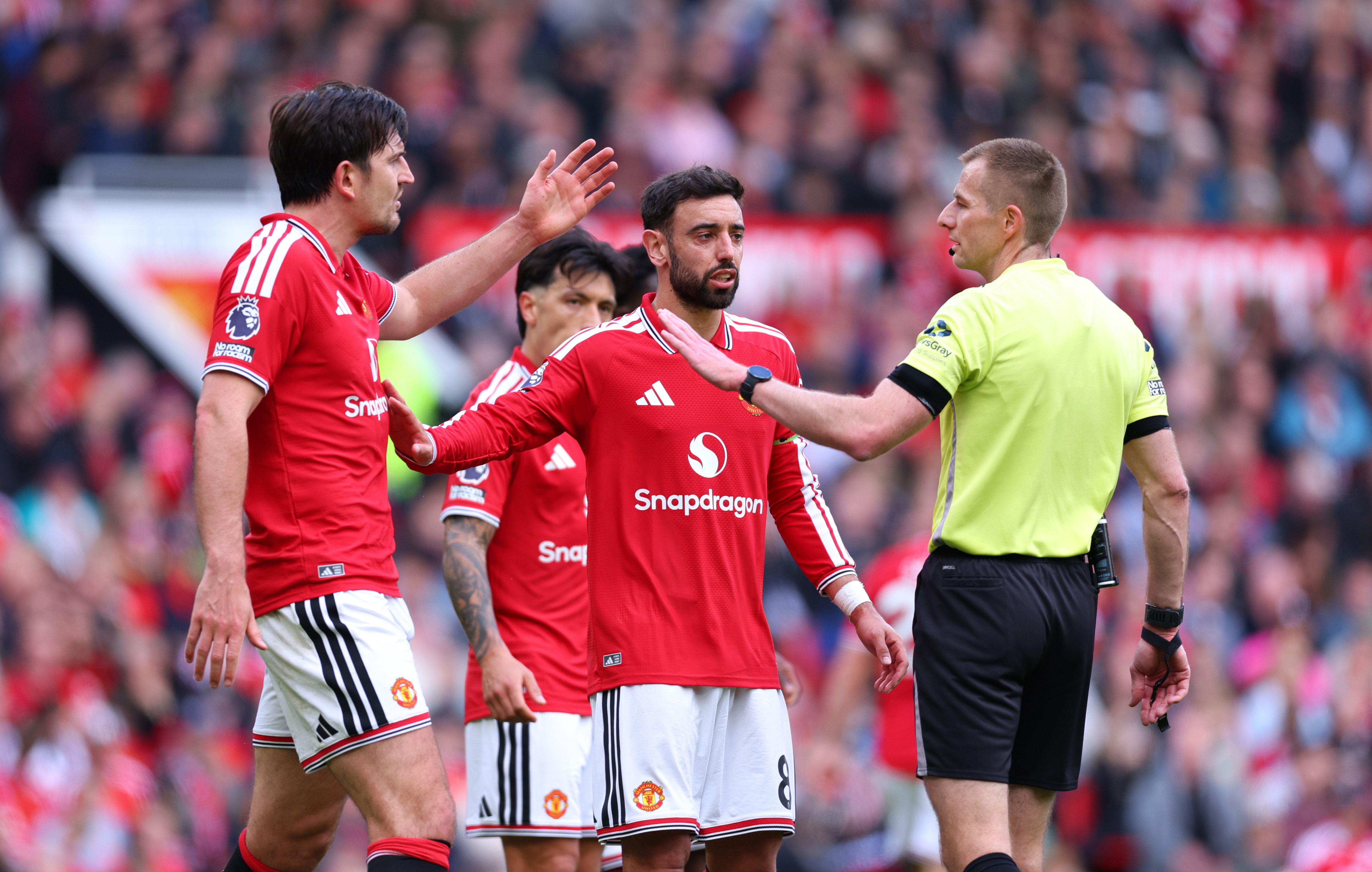 Bruno Fernandes and Harry Maguire speak to the referee