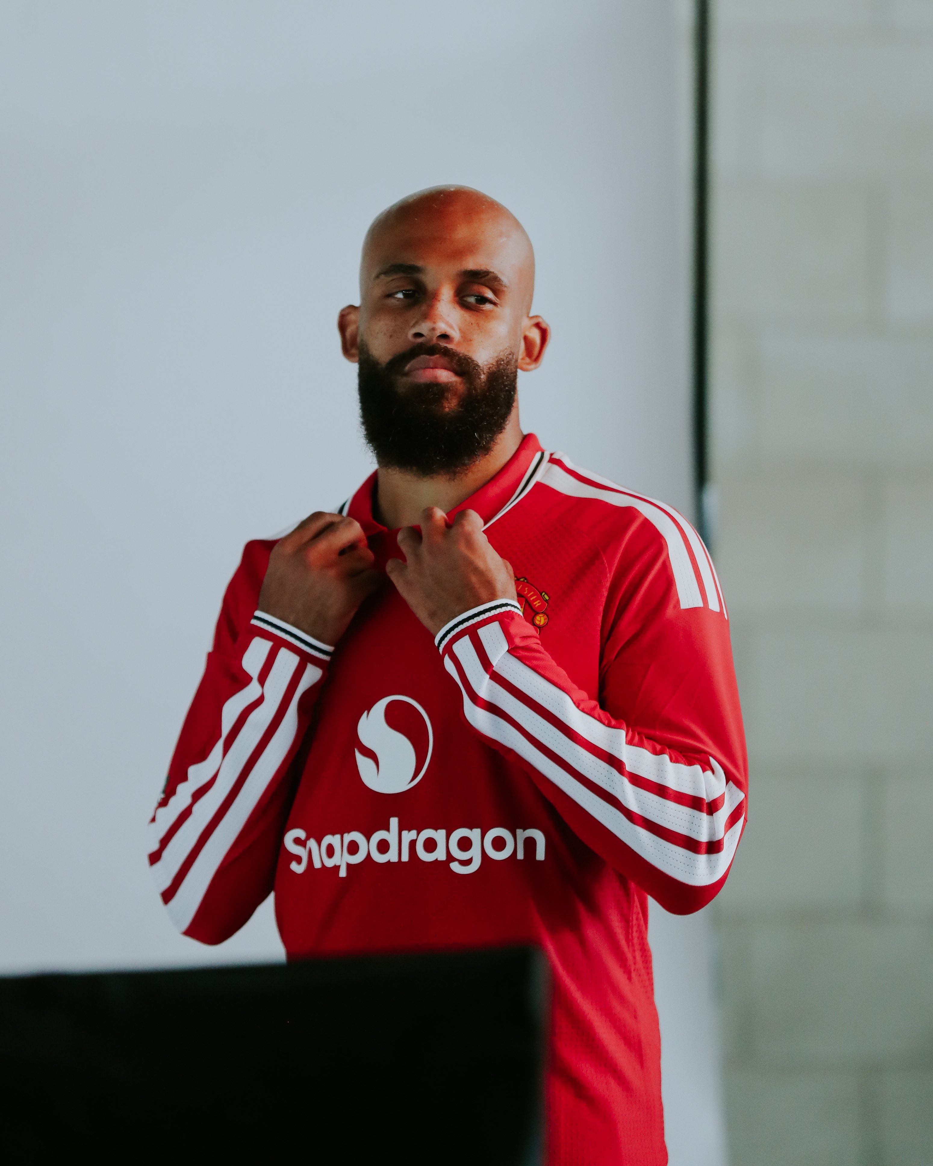 Bryan Mbeumo poses in red shirt