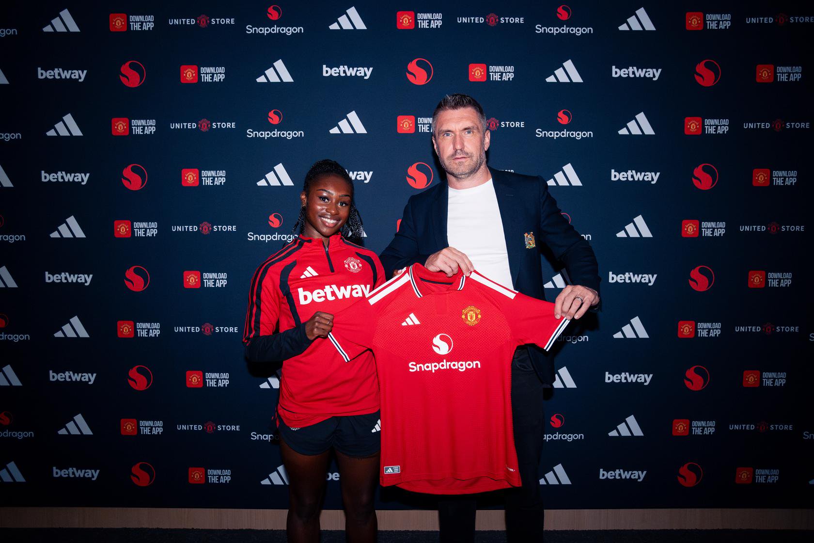 Monica Jusu Bah holding up United shirt with Matt Johnson