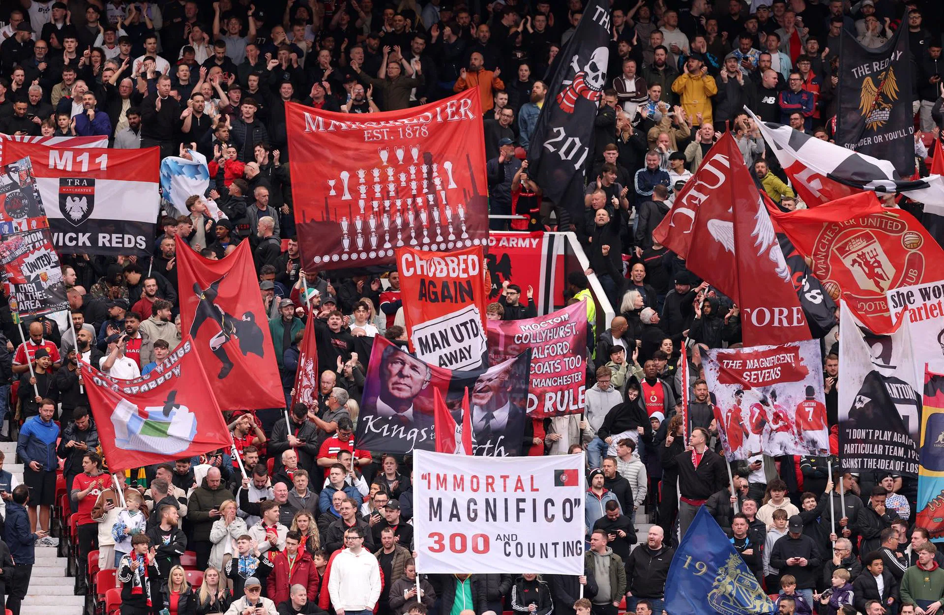Manchester United fans holding flags in Old Trafford