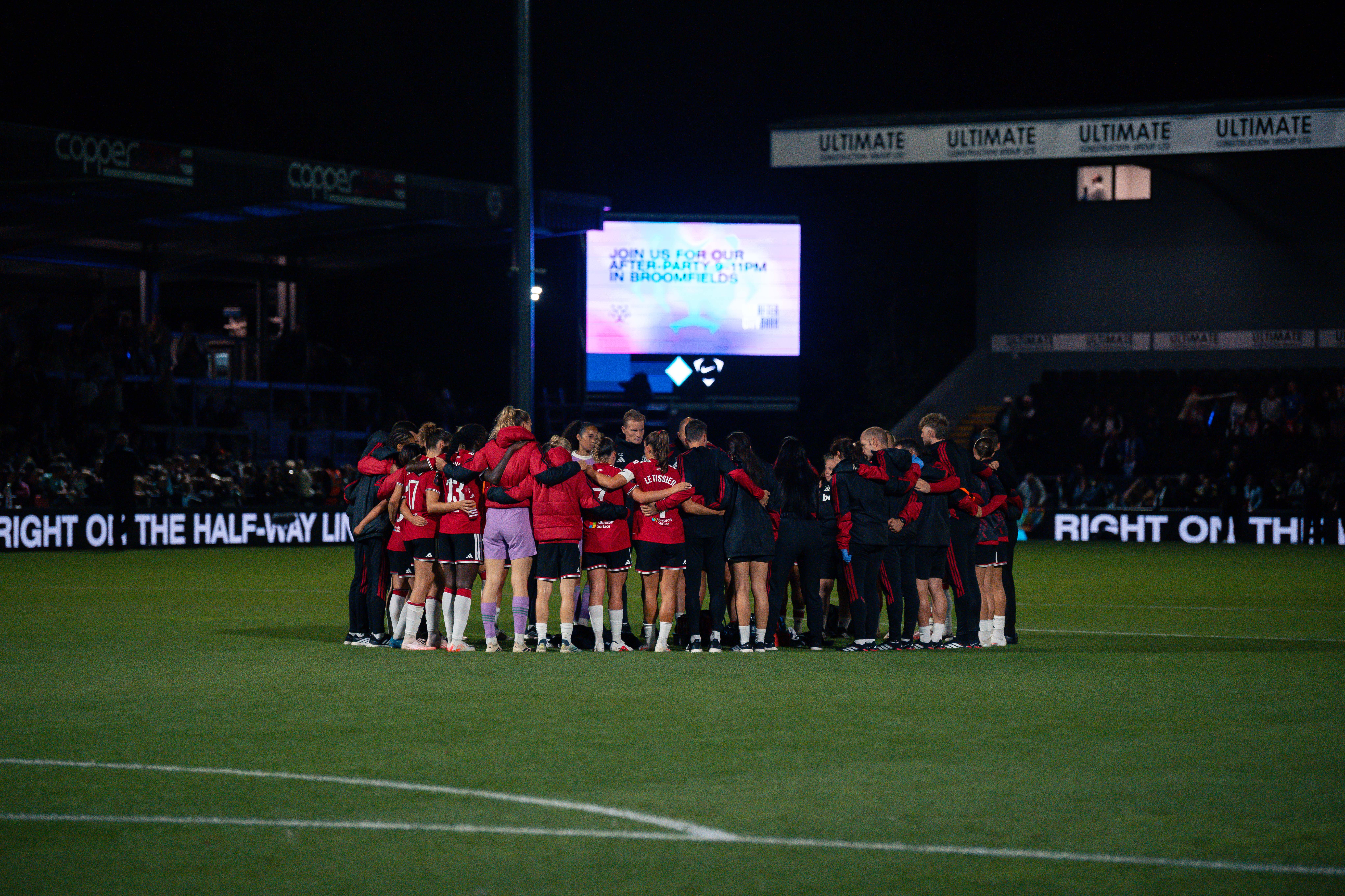 United Women players in a huddle